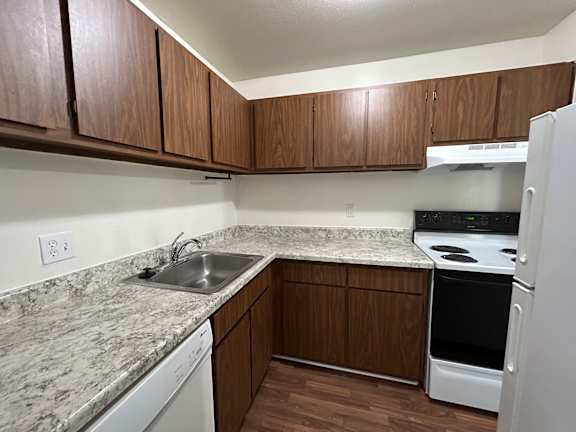 A kitchen with a white dishwasher and white refrigerator.