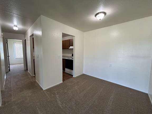 A spacious bedroom with carpeted floor and white walls.