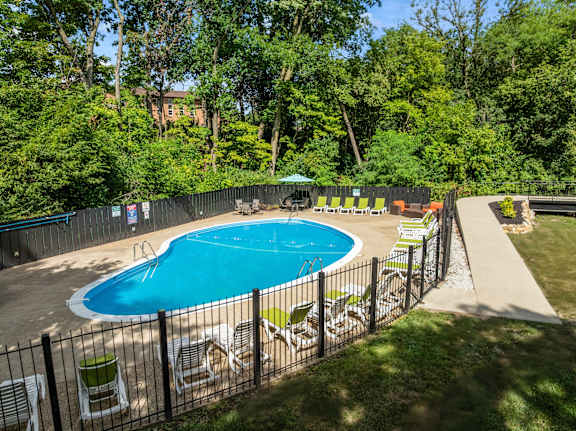 A pool surrounded by a fence and trees
