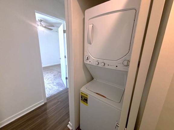 A white dishwasher is in a narrow hallway.