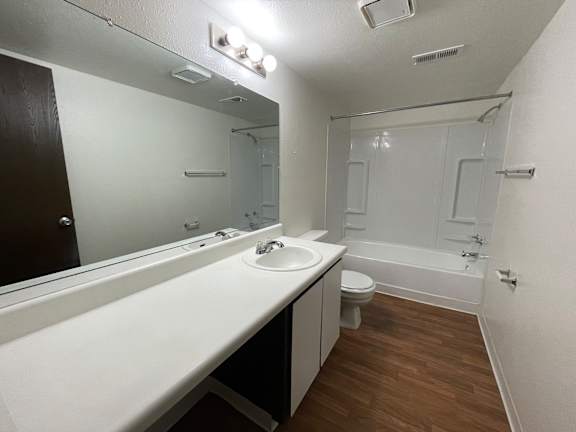 A bathroom with a white countertop and a white sink.