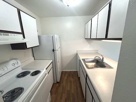 A kitchen with white appliances and cabinets.