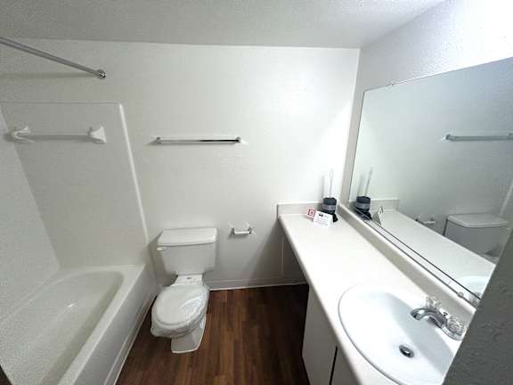 A white bathroom with a toilet, sink, and bathtub.