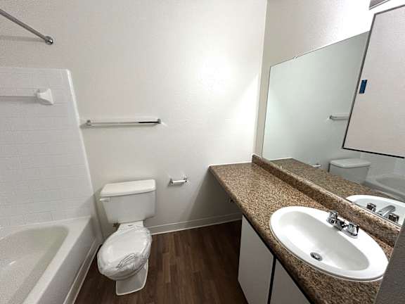 A white toilet sits in a bathroom next to a sink.