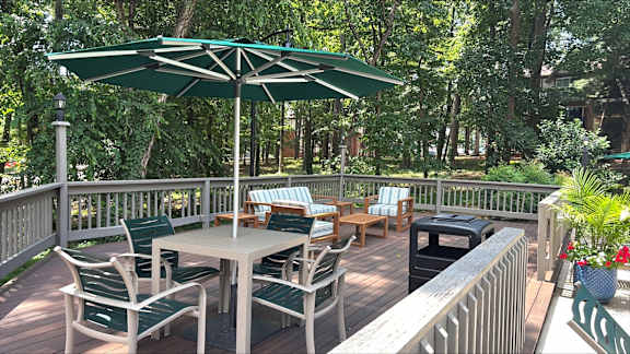 A patio with a table and chairs under an umbrella.