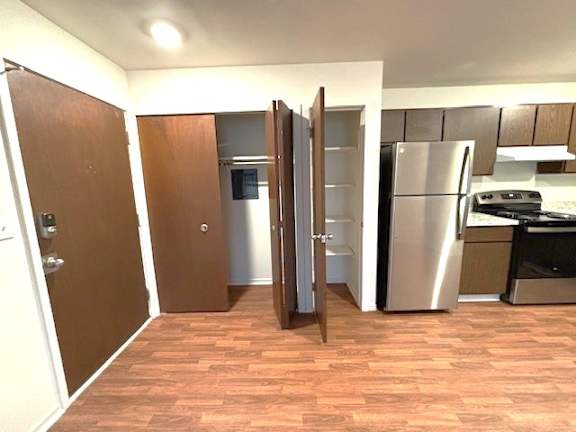 A kitchen with a refrigerator, oven, and microwave.