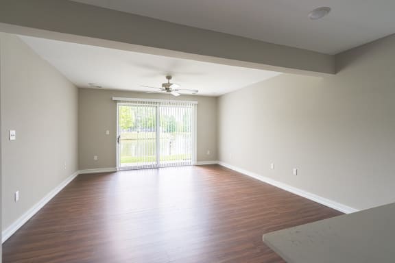 a bedroom with hardwood floors and a ceiling fan at Hillside Apartments, Wixom