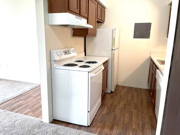 A kitchen with a white oven and refrigerator.