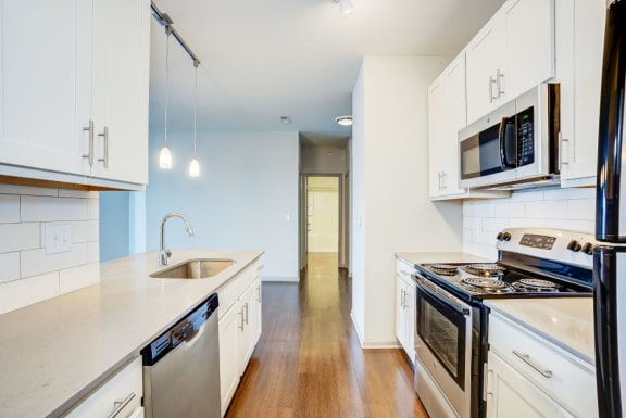 a kitchen with white cabinets and stainless steel appliances at The Avenue at Polaris Apartments, Columbus, OH