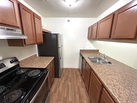 A kitchen with brown cabinets and a black stove top oven.