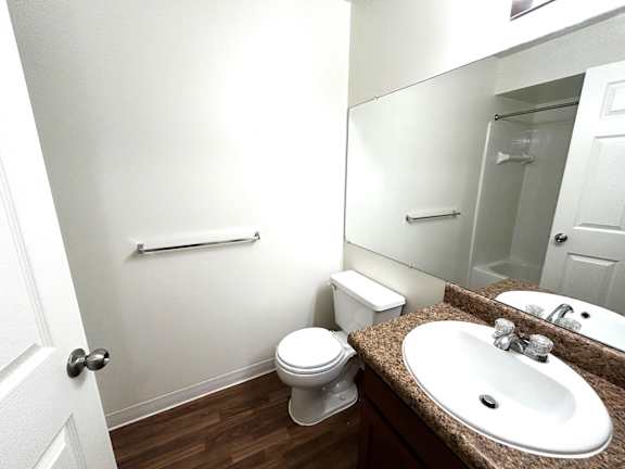 A white toilet sits in a bathroom next to a sink.