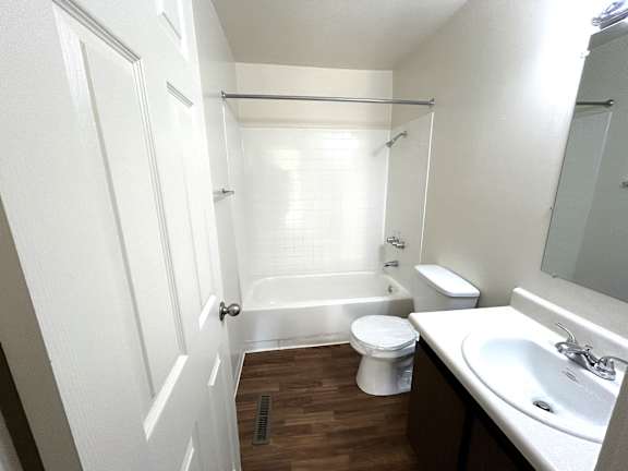 A white bathroom with a toilet, sink, and bathtub.
