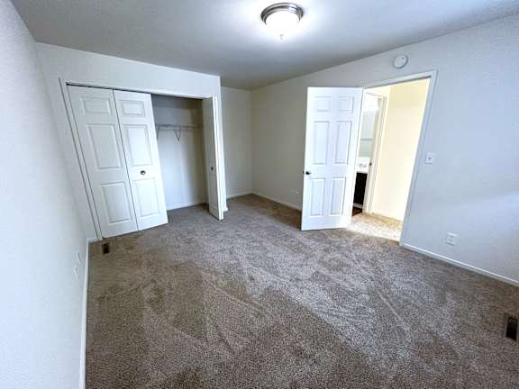A beeroom with carpeted floor and two white doors.