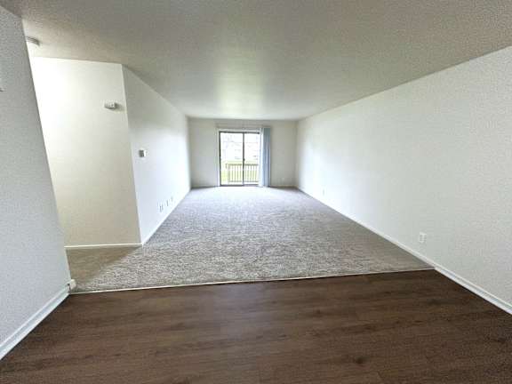 A living room with carpeted floors and white walls.