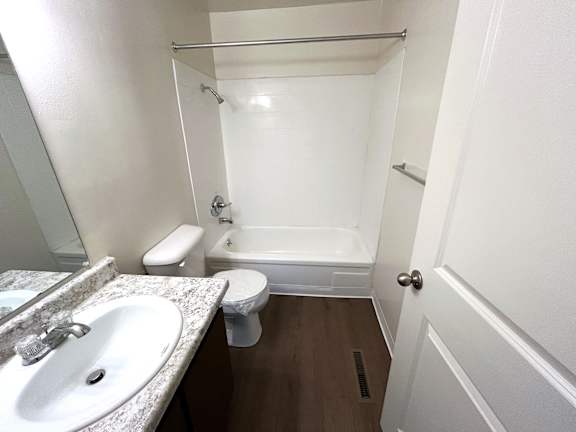 A white bathroom with a toilet, sink, and bathtub.