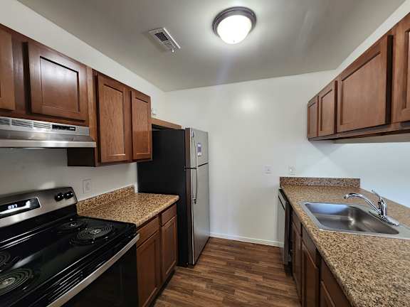 A kitchen with wooden cabinets and a black stove top oven.