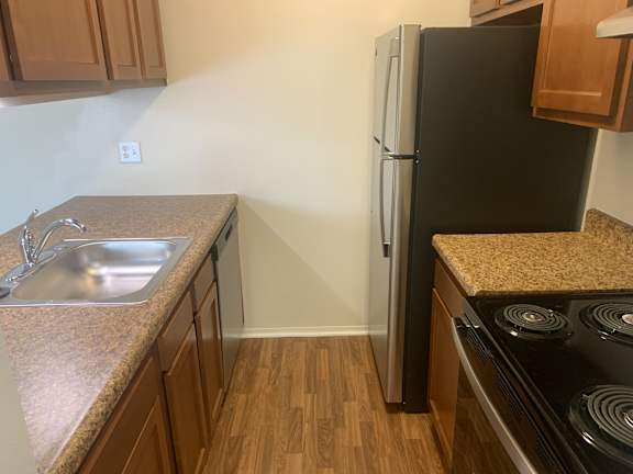 A kitchen with brown cabinets and stainless steel appliances