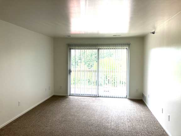 The living room with patio window and balcony.
