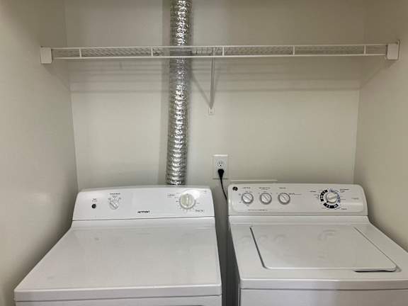 A white washer and dryer in a closet.