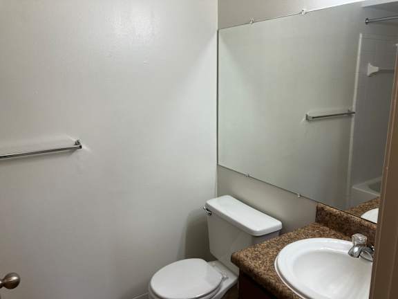 A white toilet sits next to a sink in a bathroom.