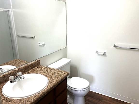 A white toilet sits next to a sink in a bathroom.