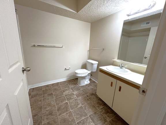 Bathroom with vanity cabinet and large mirror at Heatherwood Apartments, Grand Blanc, 48439