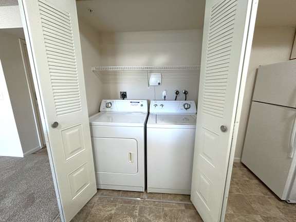 Closet laundry with side by side washer and dryer at Heatherwood Apartments, Grand Blanc, Michigan