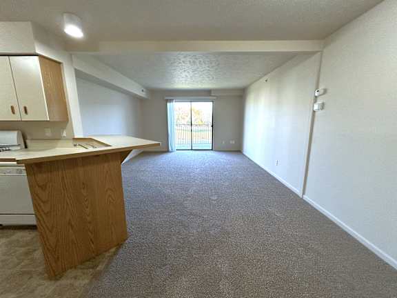Open living area with kitchen and patio access at Heatherwood Apartments, Grand Blanc, MI