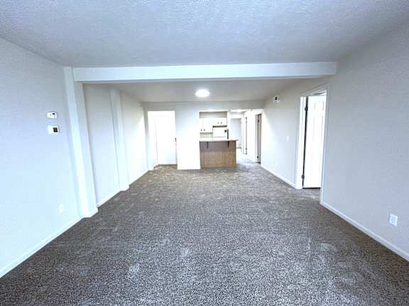 Open basement with carpeted floor and kitchen area at Heatherwood Apartments, Grand Blanc, MI 48439