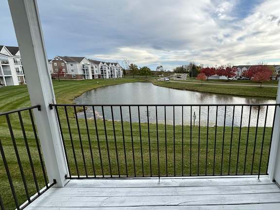 Balcony view of pond and residential buildings at Heatherwood Apartments, Grand Blanc, MI