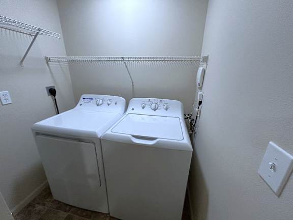 Laundry closet with washer and dryer at Heatherwood Apartments, Michigan