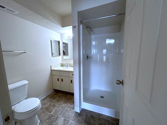 Bathroom with white fiberglass shower stall at Heatherwood Apartments, Michigan, 48439