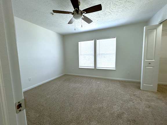Unfurnished bedroom with ceiling fan and window blinds at Heatherwood Apartments, Grand Blanc, MI