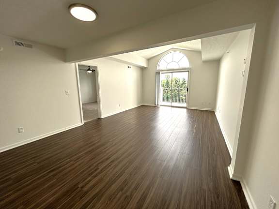 Spacious living room with arched balcony door at Heatherwood Apartments, Grand Blanc, 48439
