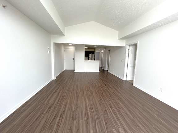 Open living room with wood flooring and kitchen at Heatherwood Apartments, Grand Blanc