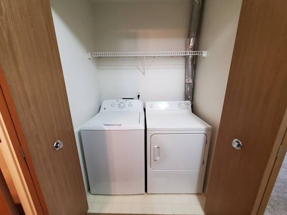 A laundry closet with a washer and dryer.