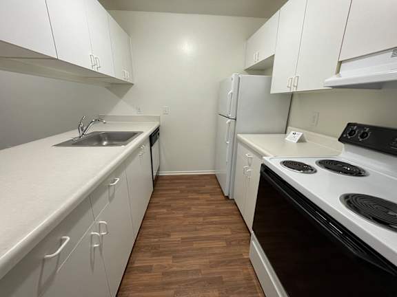 A kitchen with white cabinets and a black stove top.