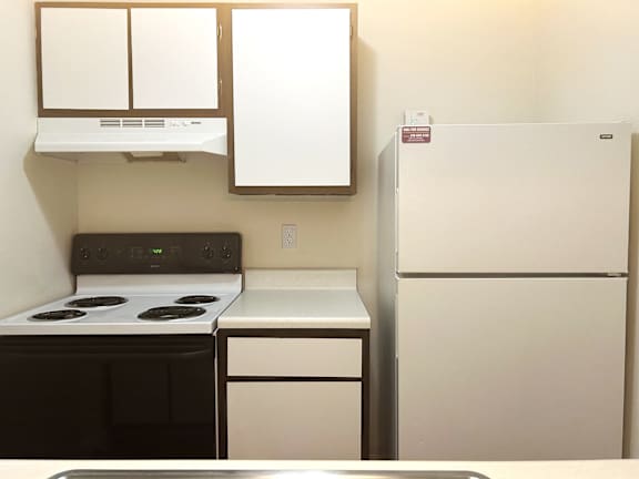 A kitchen with a black stove top and white appliances.