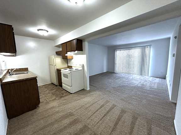 A kitchen area with a sink, refrigerator, and oven.