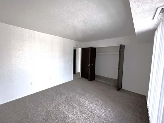 A bedroom with a carpeted floor and a white ceiling.