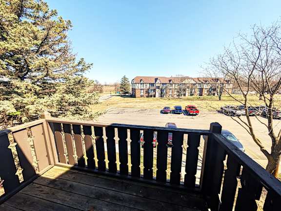 Balcony view overlooking parking area and residential buildings at Charter Oaks Apartments, Davison, 48423