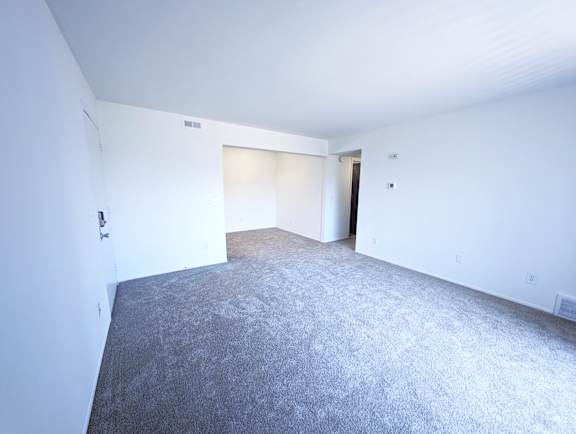 Spacious carpeted room with connecting hallway at Charter Oaks Apartments, Michigan, 48423