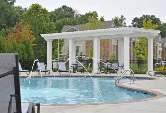 a swimming pool with a pergola and patio furniture
