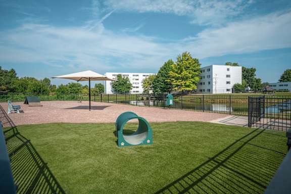 A playground with a green slide and a white building in the background at Alexandria of Carmel Apartments, Carmel, Indiana