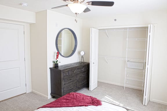 a bedroom with a closet and a bed and a mirror  at Andover Pointe Apartment Homes, La Vista, 68138