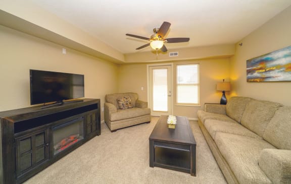 a living room with a couch and a tv  at Andover Pointe Apartment Homes, La Vista