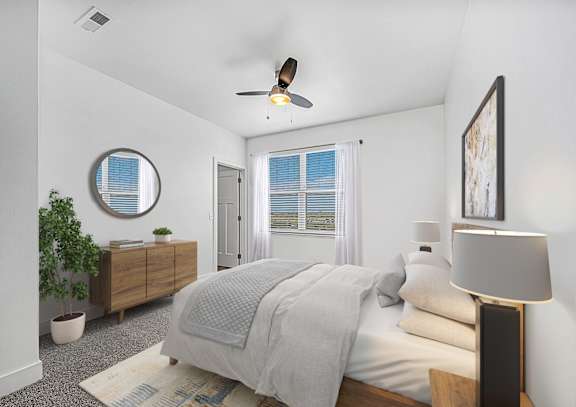A bedroom with a bed, a ceiling fan, and a window with blinds at Andover Pointe Apartment Homes, La Vista, NE, 68138