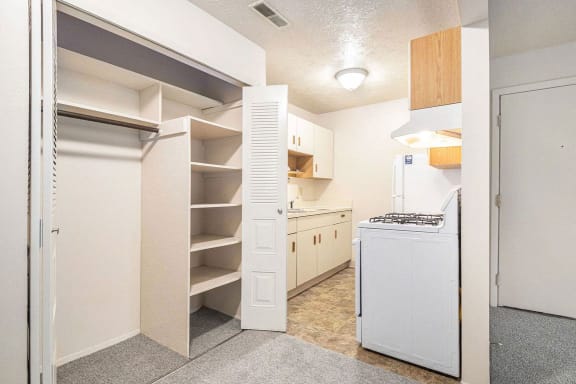 a renovated kitchen with white appliances and a closet at Apple Ridge Apartments, Walker