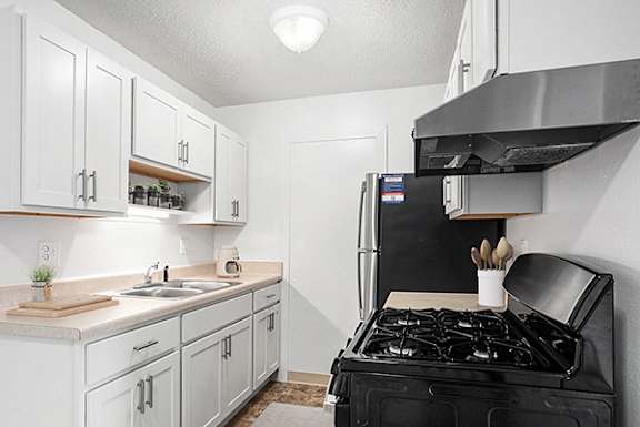 an upgraded kitchen with white cabinets and stainless steel appliances at Apple Ridge Apartments in Walker, MI