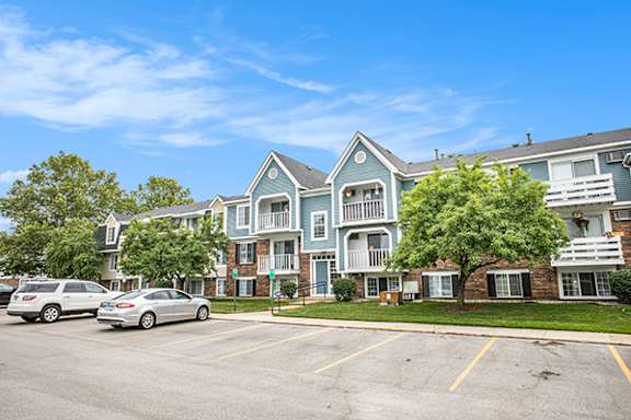 A blue building with a parking lot in front of it at Apple Ridge Apartments, MI, 49534